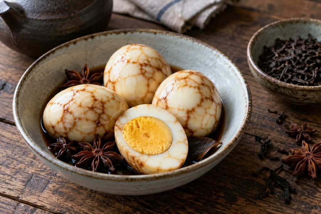 Marmorerte teegg i en skål, med et delt egg med fast plomme