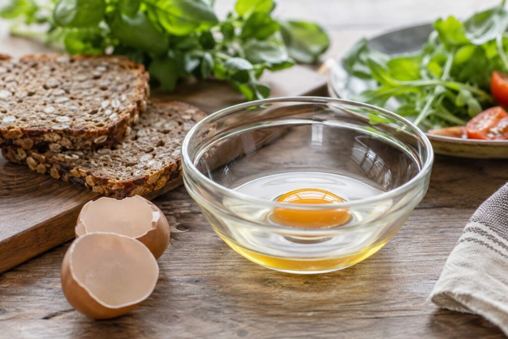 Knekt egg i glasskål ved grønnsaker og grovt brød